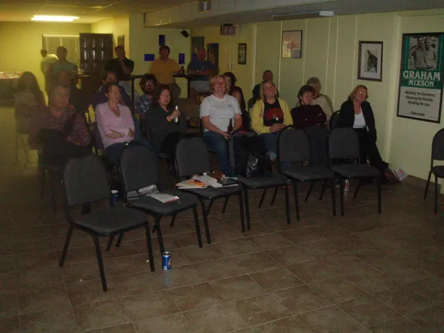 As we can see in the image there are few people here and there, chairs, books, wall, banner, photo...